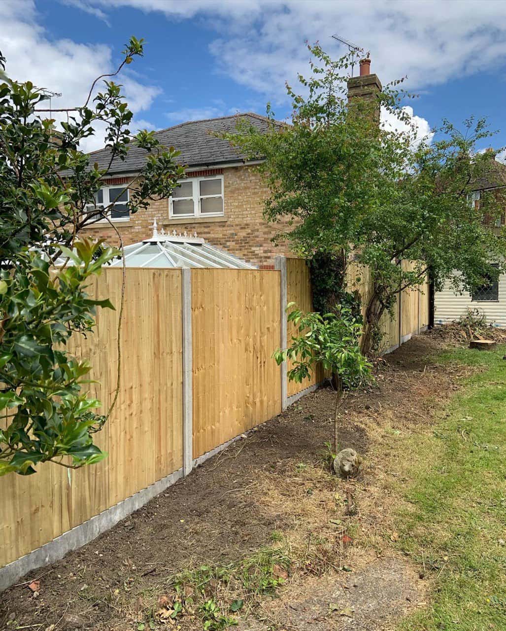This is a photo of fence panels installed in a residential garden using concrete posts and gravel boards. Installed by Fast Fix Fencing Downham Market
